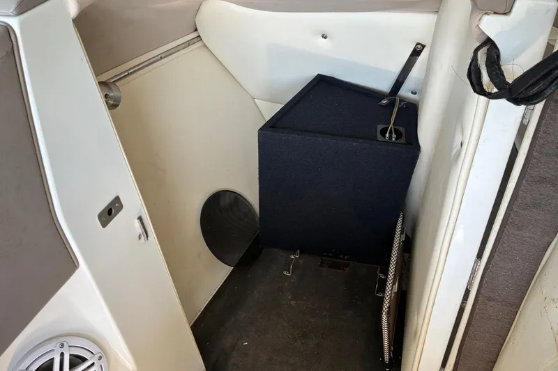 Slide: The Image of Interior of a 2000 Cobalt 246 boat, featuring storage space and speaker. - 16