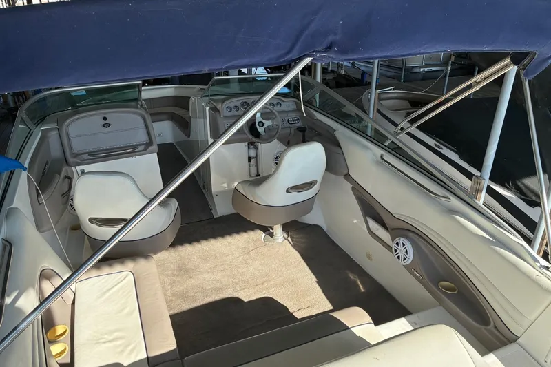 Slide: The Image of 2000 Cobalt 246 boat interior with seating, steering wheel, and canopy. - 9