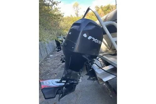 Slide: The Image of 2009 Bennington Cruise 20 boat with an Evinrude outboard motor, parked outdoors. - 4
