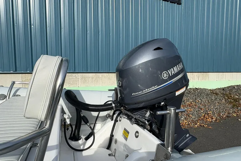 Slide: The Image of 2024 Ribcraft 4.8T boat with Yamaha four-stroke engine, docked near blue building. - 10
