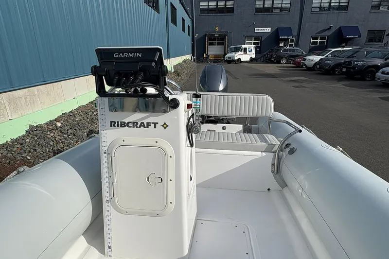 Slide: The Image of 2024 Ribcraft 4.8T boat with Garmin navigation, docked near industrial building. - 11