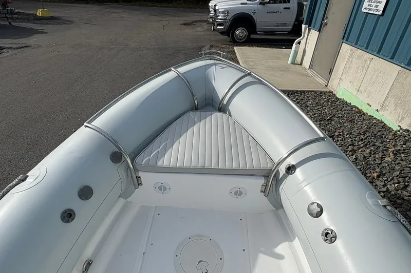 Slide: The Image of 2024 Ribcraft 4.8T inflatable boat, docked near a building, showcasing interior seating. - 12