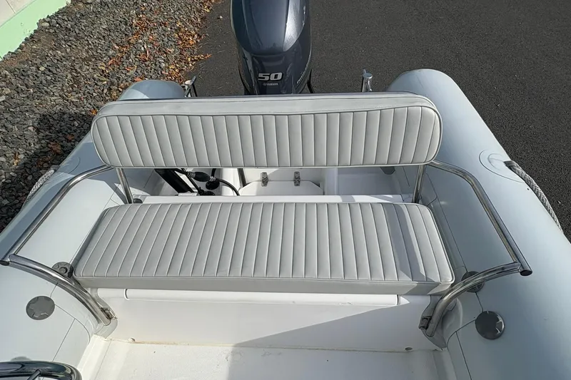 Slide: The Image of 2024 Ribcraft 4.8T boat with gray seating and Yamaha 50 engine. - 4