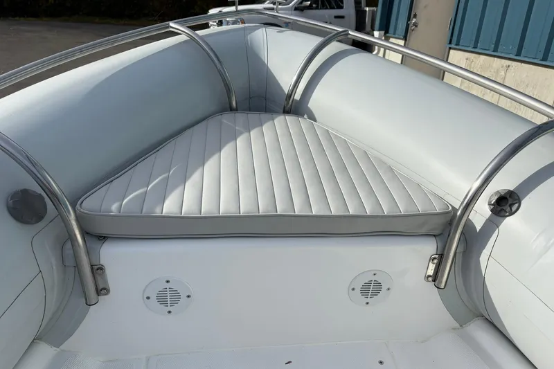 Slide: The Image of 2024 Ribcraft 4.8T boat interior with cushioned seating and stainless steel railings. - 5