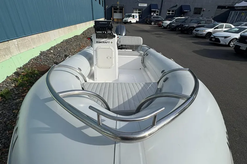 Slide: The Image of 2024 Ribcraft 4.8T inflatable boat with seating, docked in a parking area. - 8