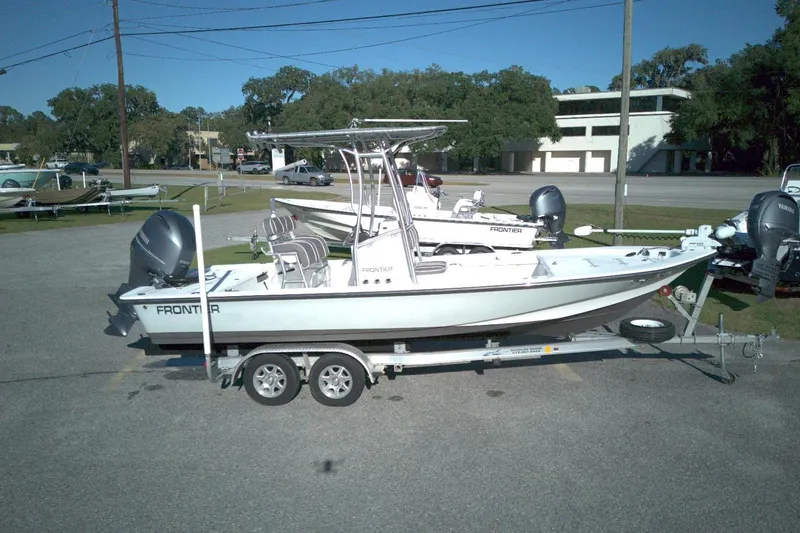 Slide: The Image of 2017 Frontier 2104 boat on trailer in parking lot, clear day. - 0