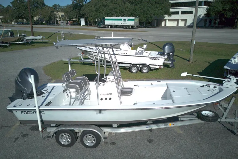 Slide: The Image of 2017 Frontier 2104 boat on trailer, parked outdoors, featuring sleek design and modern seating. - 1