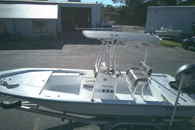 Slide: The Image of 2017 Frontier 2104 boat on trailer, parked outside a warehouse. - 8