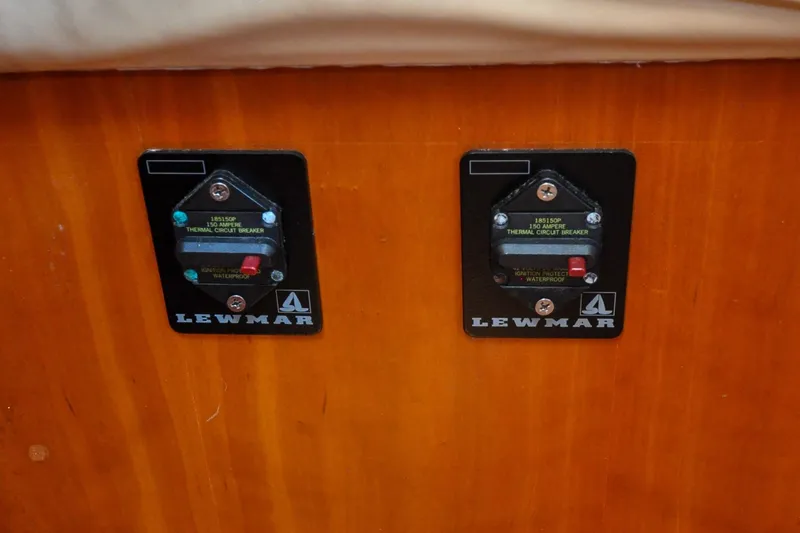 Slide: The Image of Two Lewmar thermal circuit breakers on a wooden panel, Sabre 426, 2004 model. - 105