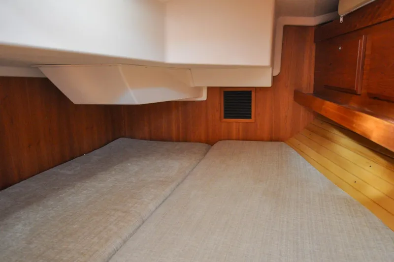 Slide: The Image of 2004 Sabre 426 yacht interior cabin with wooden paneling and cozy bedding. - 110