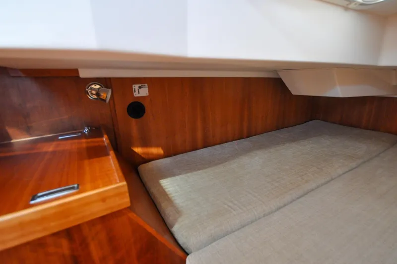 Slide: The Image of 2004 Sabre 426 yacht interior with wooden cabinetry and cushioned sleeping area. - 111