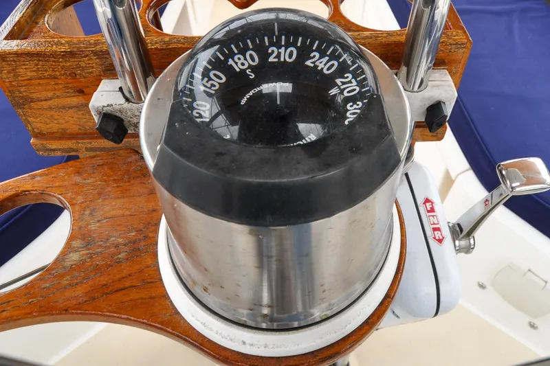Slide: The Image of Compass and throttle on 2004 Sabre 426 yacht, featuring wooden and metal elements. - 18