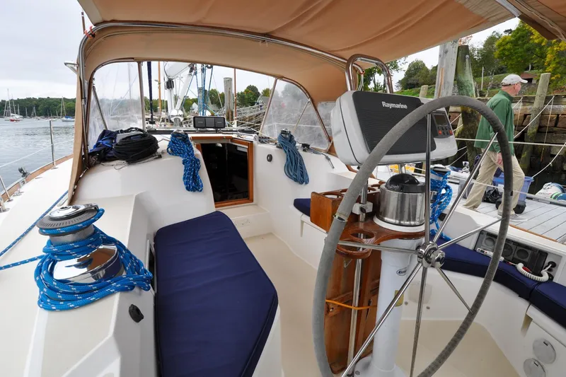 Slide: The Image of 2004 Sabre 426 sailboat cockpit with steering wheel, blue ropes, and navigation equipment. - 19