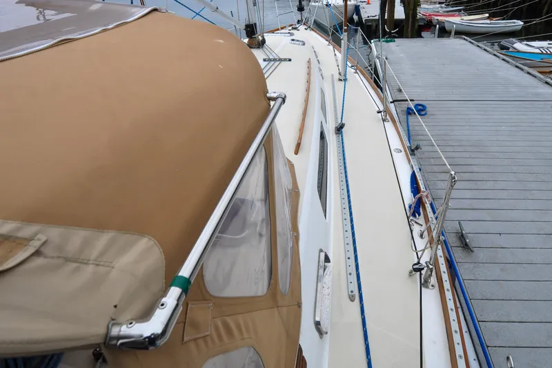Slide: The Image of 2004 Sabre 426 sailboat docked, featuring tan canopy and sleek deck design. - 32