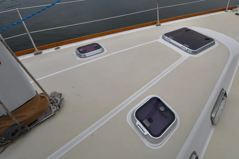 Slide: The Image of Deck of 2004 Sabre 426 sailboat with hatches and railing, on calm water. - 36