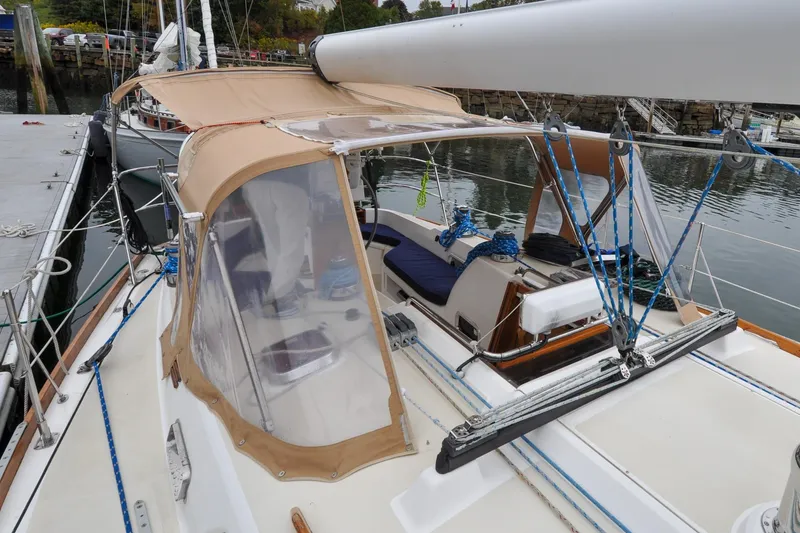 Slide: The Image of 2004 Sabre 426 sailboat docked, featuring a tan canopy and blue rigging. - 46