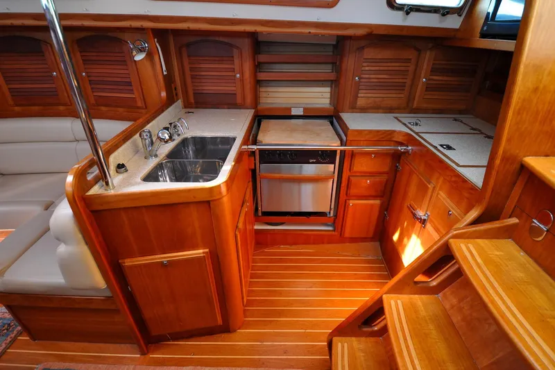 Slide: The Image of 2004 Sabre 426 yacht interior kitchen with wooden cabinetry and stainless steel sink. - 48