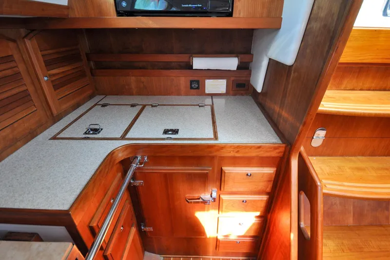 Slide: The Image of 2004 Sabre 426 yacht interior with wooden cabinetry and countertop in the galley area. - 49