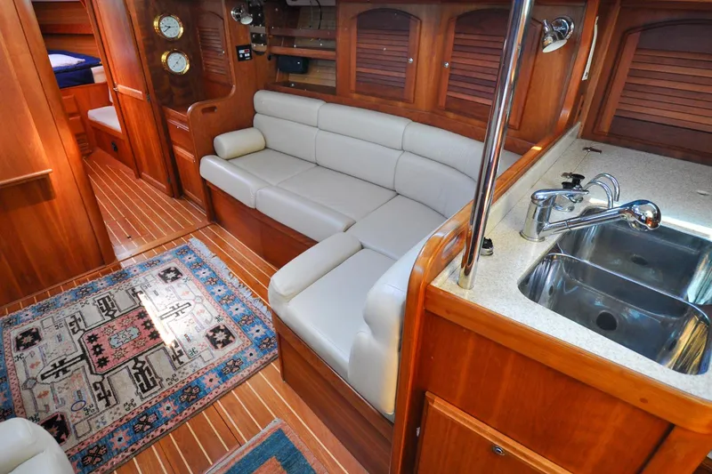 Slide: The Image of Luxurious 2004 Sabre 426 yacht interior with leather seating, wooden cabinetry, and a compact kitchen area. - 60