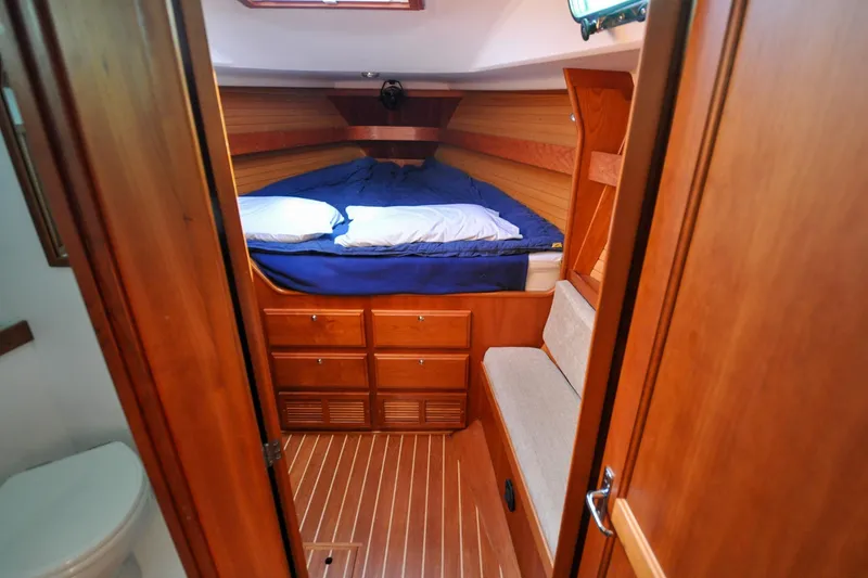 Slide: The Image of 2004 Sabre 426 yacht cabin with wooden interior and cozy bed. - 68