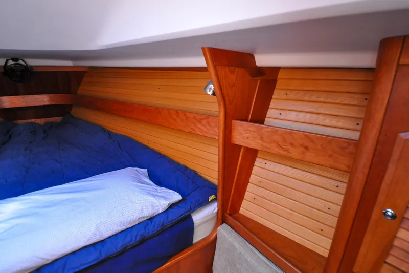 Slide: The Image of Cozy cabin interior of 2004 Sabre 426 yacht with wooden paneling and blue bedding. - 75