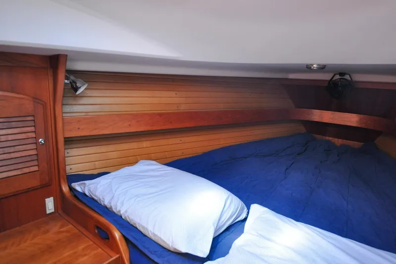 Slide: The Image of 2004 Sabre 426 yacht cabin with wooden interior and cozy bedding. - 77