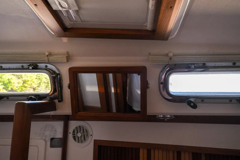 Slide: The Image of Interior of a 2004 Sabre 426 yacht with portholes and wooden accents. - 82