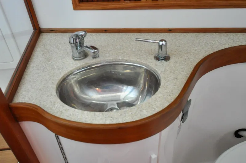 Slide: The Image of 2004 Sabre 426 yacht bathroom sink with chrome faucet and wooden trim. - 84