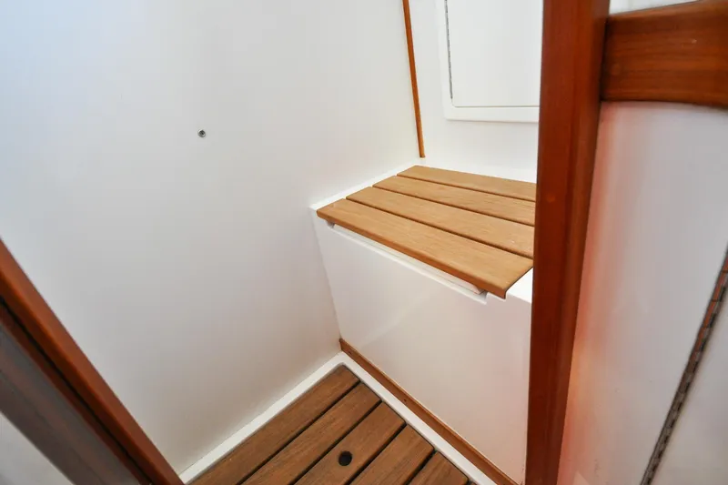 Slide: The Image of Wooden interior of 2004 Sabre 426 boat, featuring bench and flooring. - 86