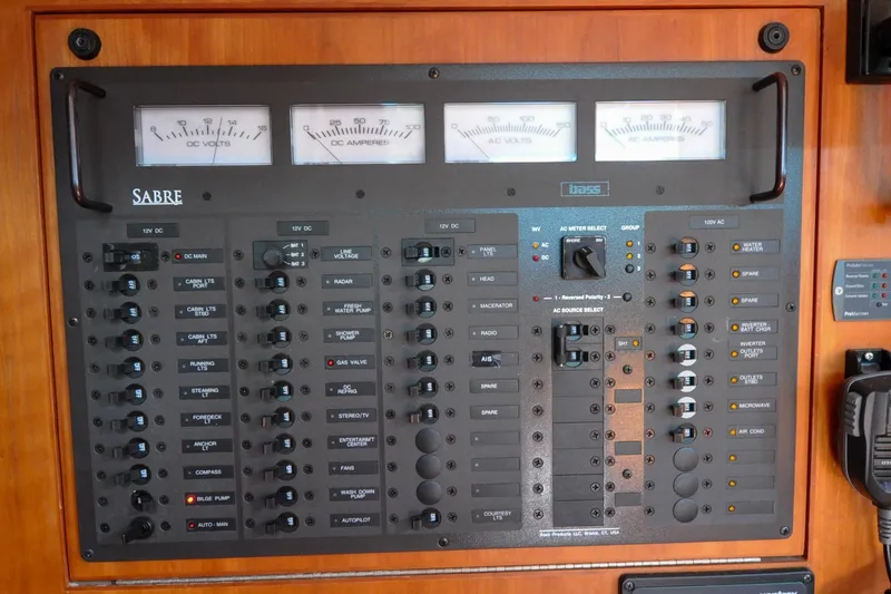 Slide: The Image of Electrical control panel of a 2004 Sabre 426 yacht with various switches and meters. - 99