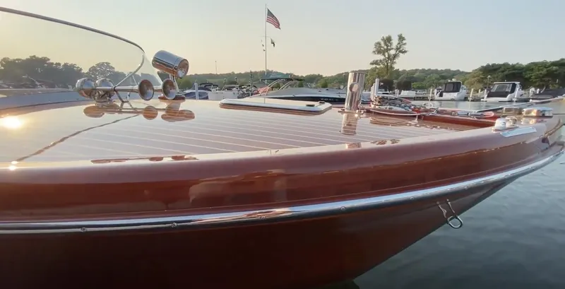 Slide: The Image of Custom 2020 Windlea Runabout boat with polished wood deck, docked near shoreline. - 7