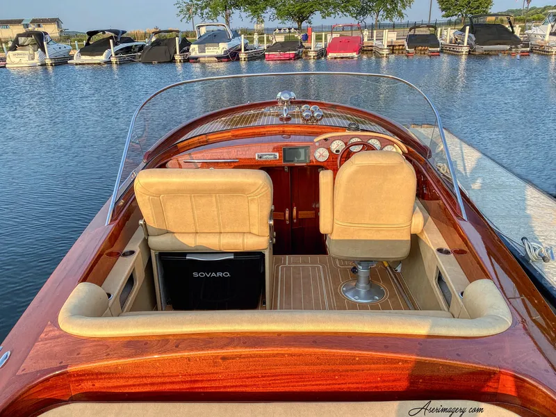 Slide: The Image of Custom 2020 Windlea Runabout boat interior at marina, featuring wooden finish and beige seats. - 9