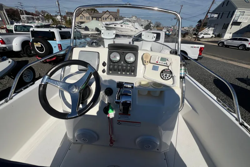 Slide: The Image of 2009 Boston Whaler 180 Dauntless boat console with steering wheel and navigation controls. - 13