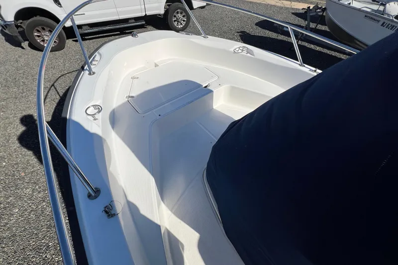 Slide: The Image of 2009 Boston Whaler 180 Dauntless boat deck with railing, parked on gravel. - 7