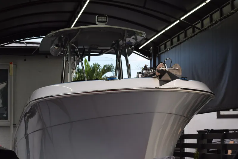 Slide: The Image of 2022 Aquasport 2300 Center Console boat with T-top and mounted spotlight. - 11