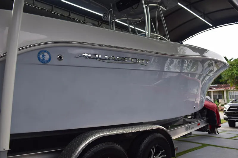 Slide: The Image of 2022 Aquasport 2300 Center Console boat on trailer, side view. - 15