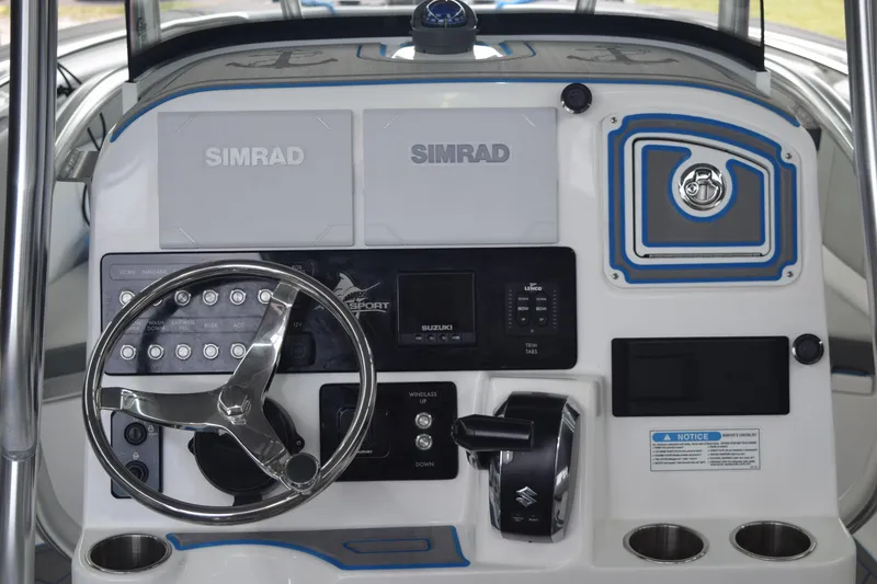 Slide: The Image of 2022 Aquasport 2300 Center Console dashboard with Simrad displays and steering wheel. - 22