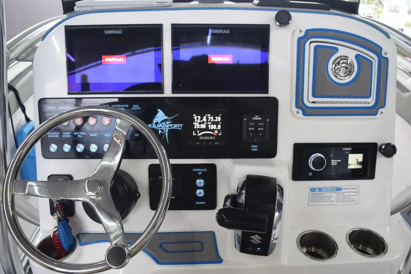 Slide: The Image of 2022 Aquasport 2300 Center Console dashboard with Simrad displays and steering wheel. - 31