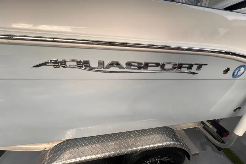 Slide: The Image of 2022 Aquasport 2300 Center Console boat in a garage, showcasing sleek design. - 4