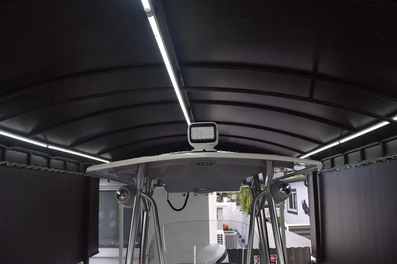 Slide: The Image of 2022 Aquasport 2300 Center Console boat under a covered storage area. - 55