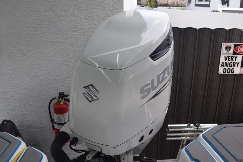 Slide: The Image of 2022 Aquasport 2300 Center Console with Suzuki outboard motor, fire extinguisher, and warning sign. - 68