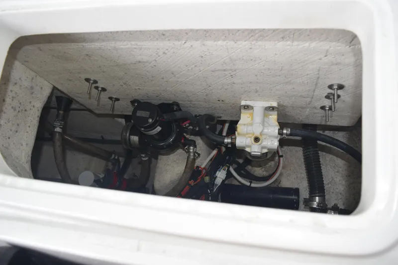 Slide: The Image of 2022 Aquasport 2300 Center Console boat compartment with visible plumbing and wiring. - 71