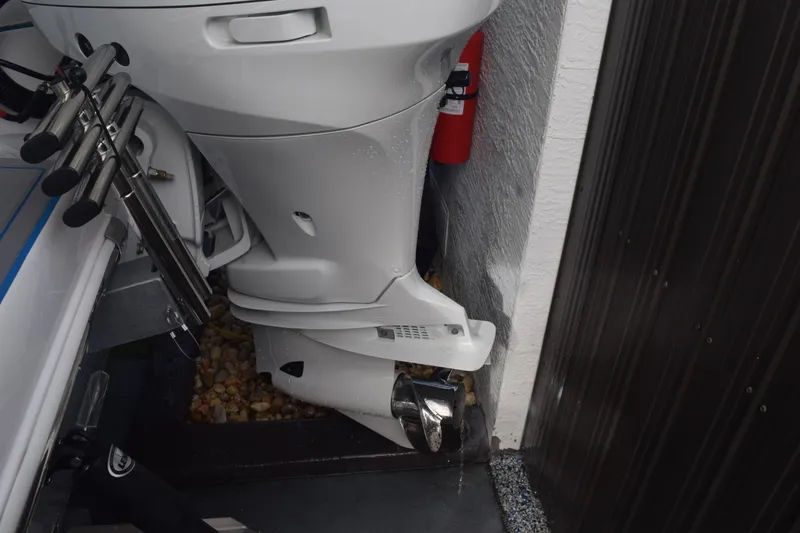 Slide: The Image of 2022 Aquasport 2300 Center Console boat engine detail with fishing rod holders. - 80