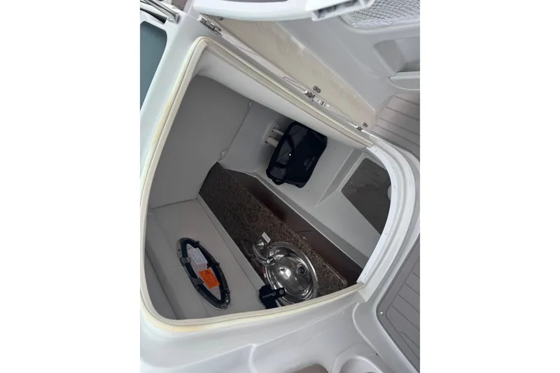 Slide: The Image of 2019 Crownline 275 SS boat interior storage compartment with safety equipment and accessories. - 17