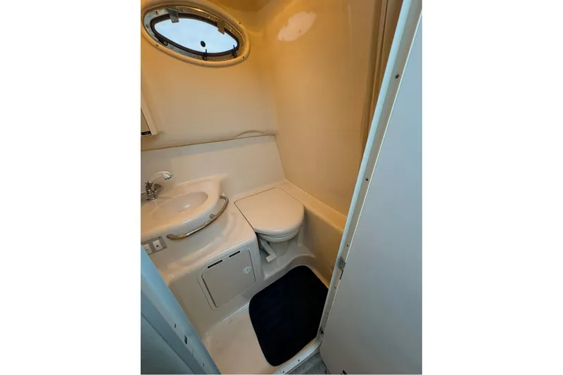 Slide: The Image of Compact bathroom in 1996 Sea Ray 290 Sundancer boat with sink and toilet. - 12