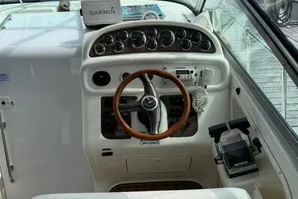 Slide: The Image of 1996 Sea Ray 290 Sundancer docked, featuring blue canopy and American flag. - 3