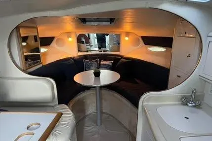 Slide: The Image of 1996 Sea Ray 290 Sundancer cabin with cozy seating and nautical-themed pillows. - 6