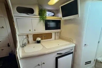 Slide: The Image of Interior of a 1996 Sea Ray 290 Sundancer boat with cozy seating and table. - 7