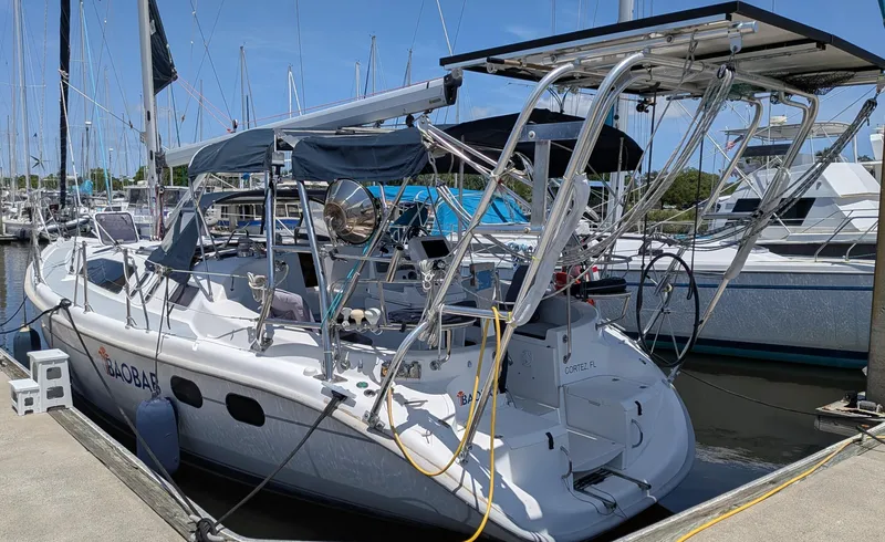 Slide: The Image of 2001 Hunter 380 sailboat docked at marina, featuring solar panels and nautical equipment. - 11