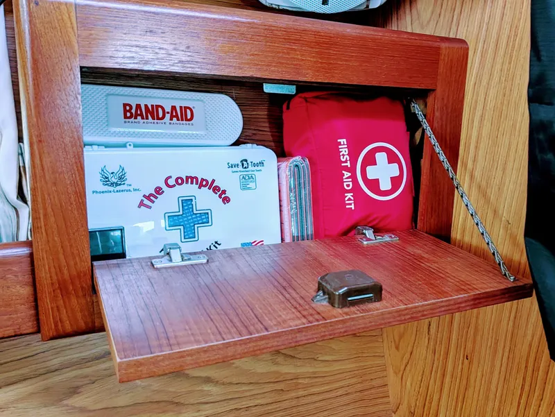 Slide: The Image of First aid kits in a wooden cabinet on a 2001 Hunter 380 boat. - 20